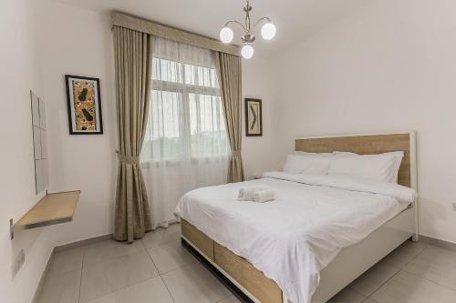 a bedroom with a large white bed with a window at Villa 371 - Al Ghadeer in Ghantoot