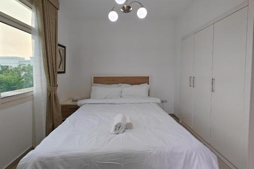 a white bed with a pair of shoes on it at Villa 371 - Al Ghadeer in Ghantoot