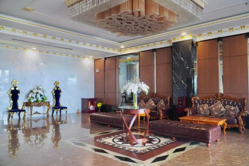 a lobby with leather couches and a table and chairs at The Mira Boutique Hotel in Thu Dau Mot