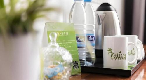 a table with a bottle of water and a coffee mug at Vatica Shanghai Jiading District Anting Metro Station Moyu Road Hotel in Shanghai