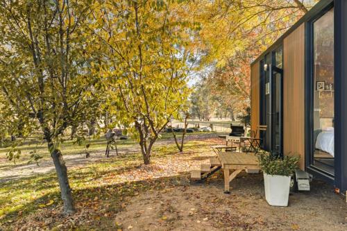 a house with a picnic table next to a tree at Tea Garden Creek Farm Retreat by Tiny Away in Milawa