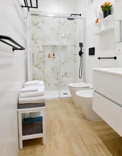 a white bathroom with a shower and a toilet at ValeVacanze in Savona