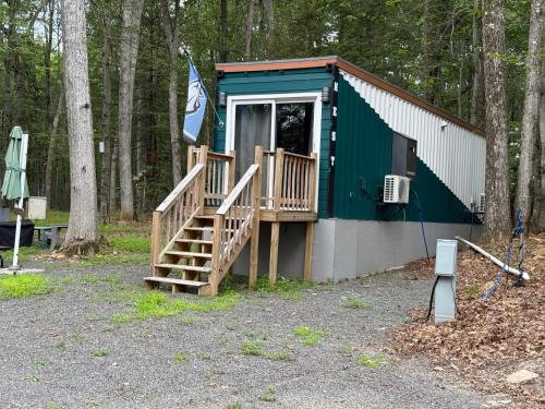 a green and white building with a porch and stairs at Camptel Poconos in Albrightsville