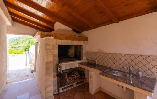 eine Küche mit einer Spüle und einer Theke mit einem Kamin in der Unterkunft Villa None Kate by Villas Guide in Dubrovnik