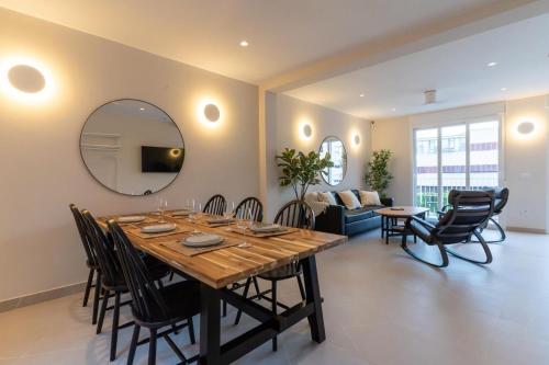 a dining room and living room with a table and a mirror at Braceli Beach Resort Middle Floor - rentafive in Santa Pola