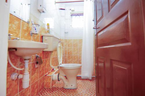 a bathroom with a toilet and a sink and a door at Perfect palm Condos-J12 in Nakuru