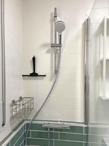 a shower in a bathroom with green and white tiles at Casa Soñiga - Congost de Montrebei in Tolva