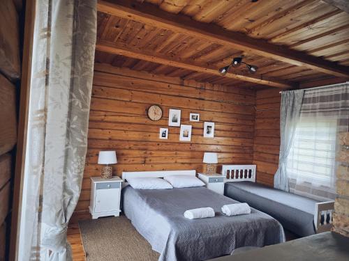 a bedroom with two beds in a log cabin at Sodyba "Vytauto kaimas" Aukštadvaris in Aukštadvaris