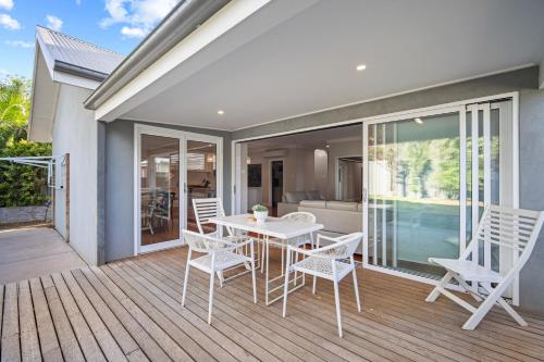 a patio with a white table and chairs on a deck at Norman's Rest Wagga in Wagga Wagga