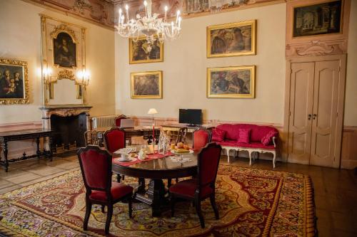 a dining room with a table and a red couch at Villa Cagnola in Varese