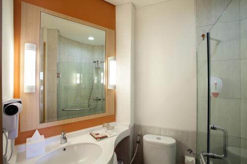 uma casa de banho com um WC, um lavatório e um chuveiro em Ibis Jakarta Harmoni em Jakarta
