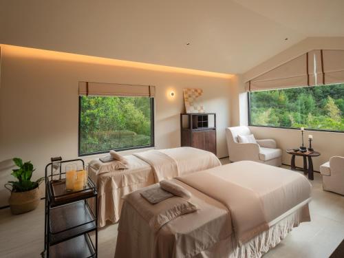 a hotel room with two beds and a window at Lijiang Jijian Xiangwang SOOOAN Luxury Resort Hotel in Lijiang