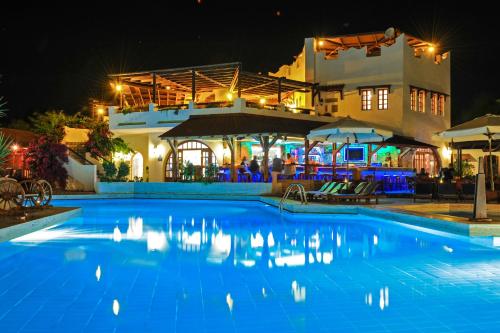a swimming pool in front of a hotel at night at Gaia Garden in Kos Town