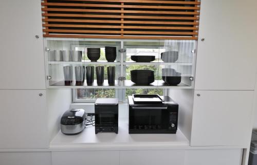 a kitchen with a microwave and other kitchen utensils at ファミーユ大室Ⅱ in Futo