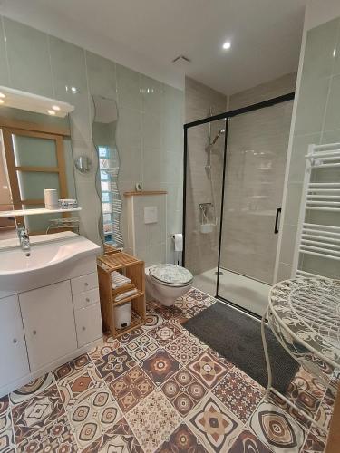 une salle de bain avec une douche, un lavabo et des toilettes dans l'établissement Chambres d'hôtes les Denias, à Saint-Paul