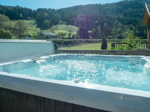 a jacuzzi tub with a mountain in the background at Woody Park Feriendorf Murau in Murau