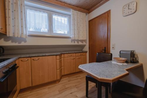 a kitchen with wooden cabinets and a table and a window at Alpenpension Haslinger in Bad Gastein
