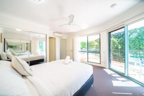 a bedroom with two beds and large windows at Beachfront Unit on The Strand in Townsville