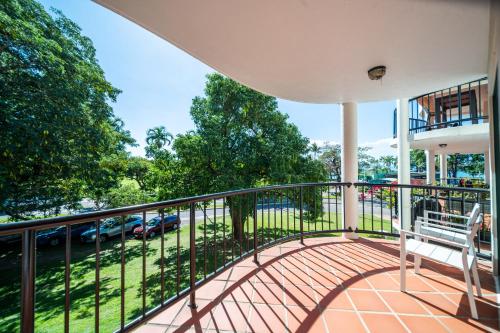 a balcony with a bench and a view of a street at Beachfront Unit on The Strand in Townsville