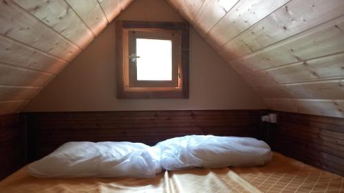 a bed in a room with a window in a attic at Saecula Natural Village Experience in Force