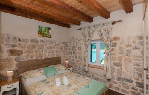a bedroom with a bed and a stone wall at Villa Janja - Makarska by Villas Guide in Donji Proložac