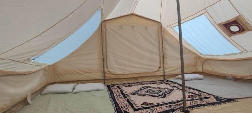 a tent with a rug inside of it at Saecula Natural Village Experience in Force