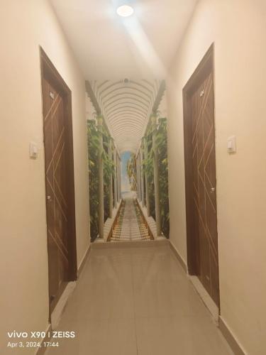 a hallway with doors and a hallway with trees at Hotel Galaxy Park in Shamshabad