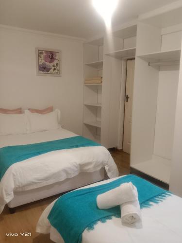 a bedroom with two beds with towels on them at Zuzani Ikhaya B&B in Grahamstown