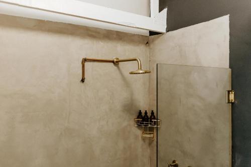 a shower in a bathroom with some bottles on a shelf at Blue Moon in Paternoster