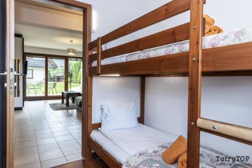 a bedroom with two bunk beds and a hallway at TatryTop Apartamenty Pardałówka in Zakopane