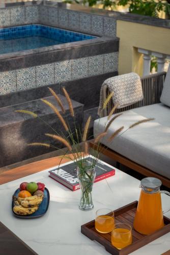 a table with a tray of fruit and a bowl of juice at Kensho Marigold 3-BHK Villa Common Pool & Lift Beaches in Majorda