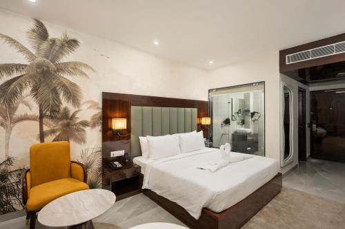 a bedroom with a large bed and a yellow chair at AVA Hotel Chandigarh Zirakpur in Zirakpur