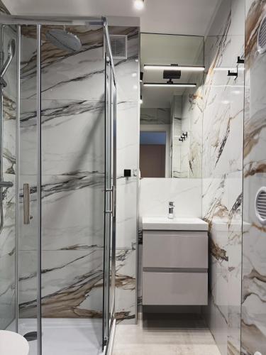 a bathroom with a shower and a sink at Apartamenty Piast Myślibórz in Myślibórz