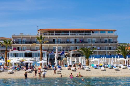 a hotel on a beach with people in the water at Hanioti GrandOtel in Hanioti