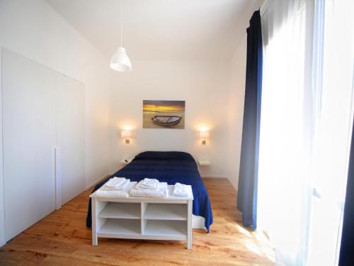 ein weißes Schlafzimmer mit einem Bett und einem Tisch in der Unterkunft Il Faro Trapani B&B in Trapani