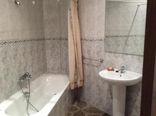 a bathroom with a sink and a bath tub next to a sink at La Abuela Maye y Me in Carrión de los Condes