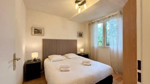 une chambre avec un lit avec deux serviettes dessus dans l'établissement Les Pieds dans le Sable – Appartement Unique avec Accès Direct à la Plage du Crotoy, au Crotoy