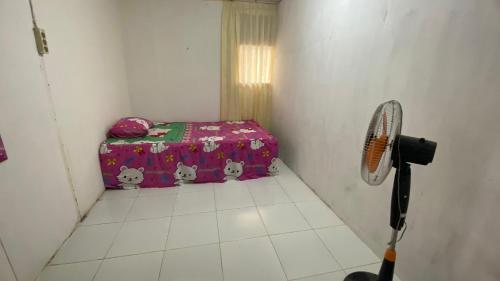 a small room with a tennis racket and a suitcase at 88HappyHomestay in Luwuk
