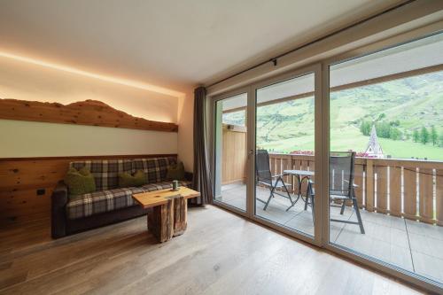 a living room with a couch and a table at Montresor Hotel Pfeldererhof in Pfelders