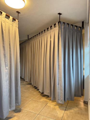 a row of curtains are lined up in a room at Habitación unos pasos de estadio GNP foro sol in Mexico City