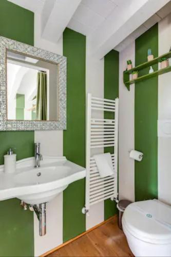 a green bathroom with a sink and a toilet at the green home in Ravenna