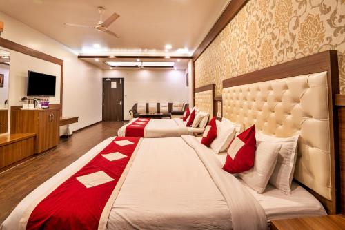 a bedroom with two beds with red pillows at Hotel The Royal Krishna in Katra