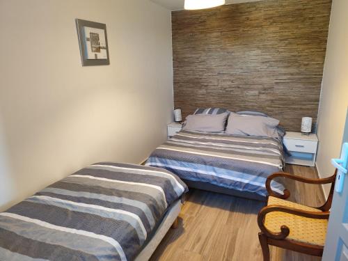 a bedroom with two beds and a chair at Mimosas - villa in Fréjus