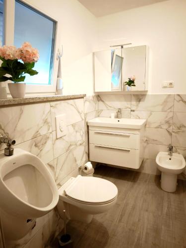 a white bathroom with a sink and a toilet at Na brigu in Livno
