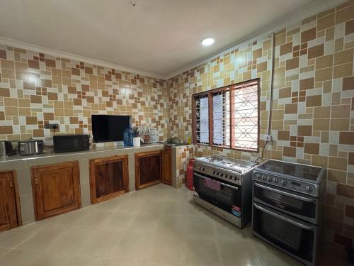 a kitchen with a stove and a sink at Cozy Stay Near Zanzibar Airport in Zanzibar City