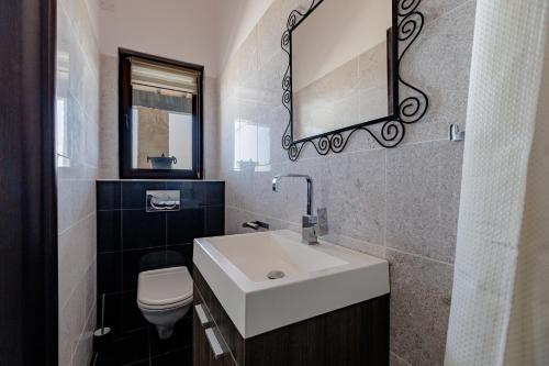 a bathroom with a white sink and a toilet at Villa EaglesRock & Spa - Droushia in Droushia