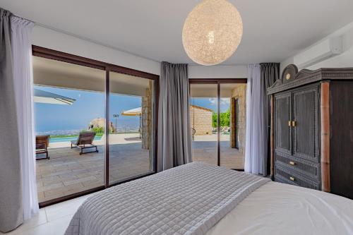 a bedroom with a bed and a view of the ocean at Villa EaglesRock & Spa - Droushia in Droushia