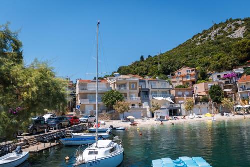 a group of boats are docked at a beach at Apartmani Spajić Duboka by aneo travel in Klek