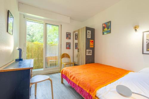 a bedroom with a bed and a desk and a window at Le Mérignac Cozy Corner - T3 & Terrasse in Mérignac