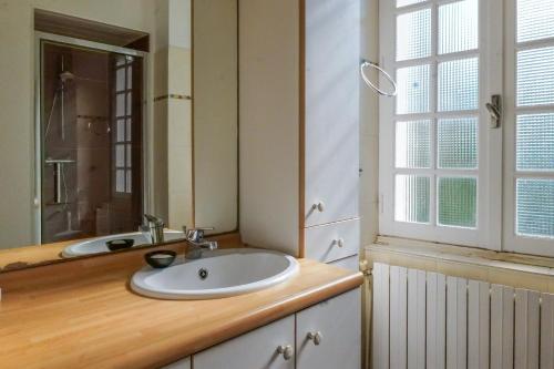 ein Badezimmer mit Waschbecken und Spiegel in der Unterkunft Maison bourgeoise - centre ville - 7 personnes in Les Sables-dʼOlonne
